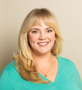 Smiling blonde woman in teal top