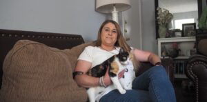 Woman sitting on couch holding calico cat