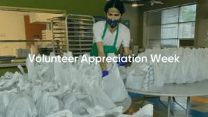 Masked volunteer packing meal bags