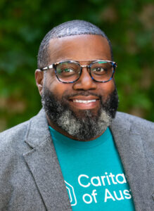 Smiling man wearing glasses and teal shirt