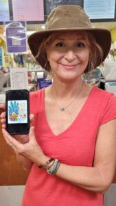 Smiling woman in hat holding phone artwork