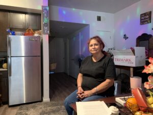 Person sitting at table in apartment kitchen