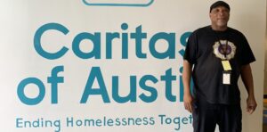 Man standing by Caritas of Austin sign