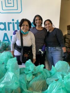 Three volunteers packing green food bags