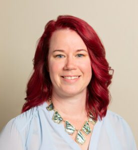 Smiling woman with red hair and necklace