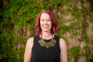 Smiling red-haired woman with gold necklace