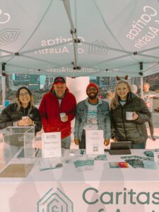 Volunteers smiling at Caritas outreach booth