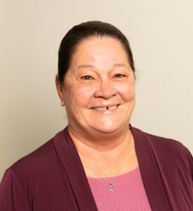 Smiling woman wearing maroon cardigan and pink top