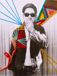 Man wearing sunglasses with colorful yarn art