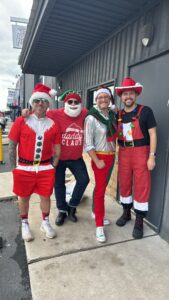 Four adults in festive Christmas costumes
