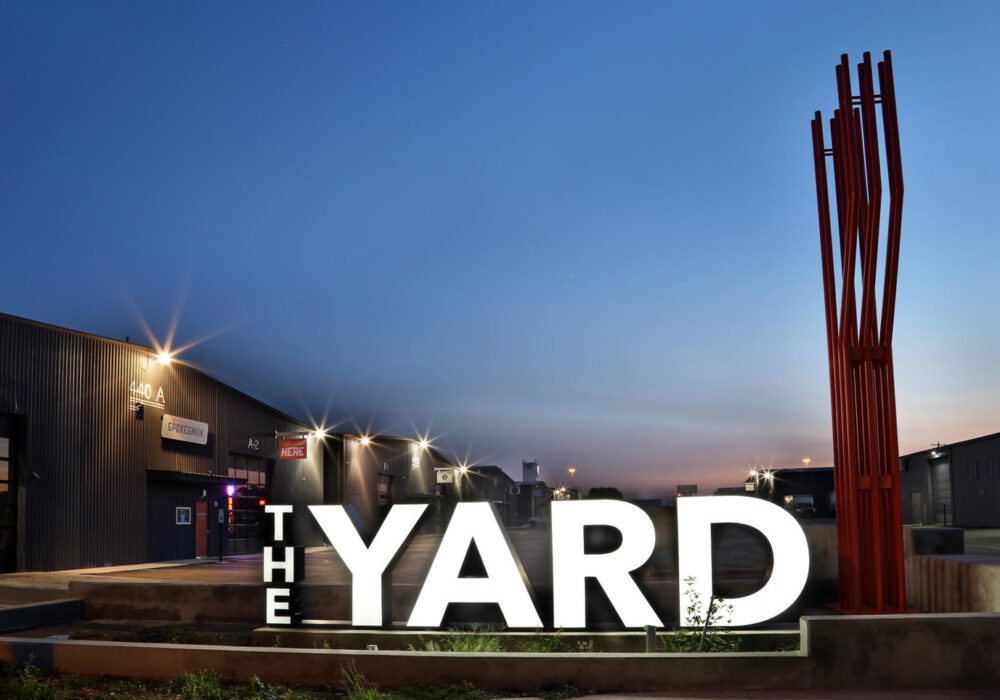 Large illuminated THE YARD sign at dusk