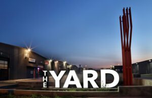 Large illuminated THE YARD sign at dusk