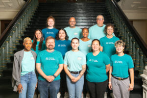 Group of people in teal shirts on staircase