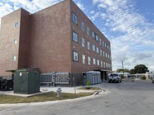 Four-story brick building with parking and portable restrooms