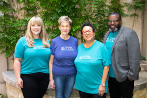 Four volunteers in blue and teal shirts