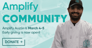 Smiling chef next to Amplify Austin banner