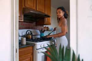 Young woman cooking on gas stove