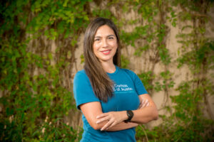 Smiling woman in teal shirt outdoors